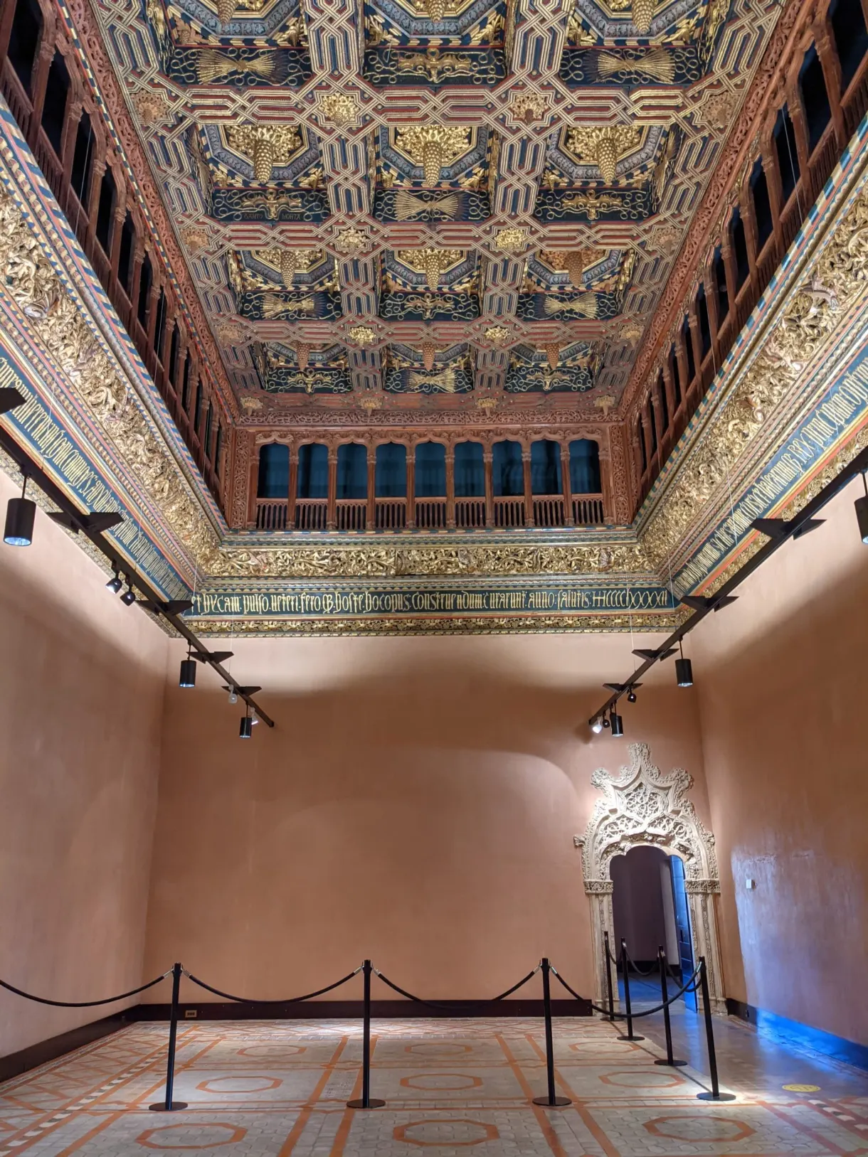 Plafond à caissons dorés d'une salle aux murs roses