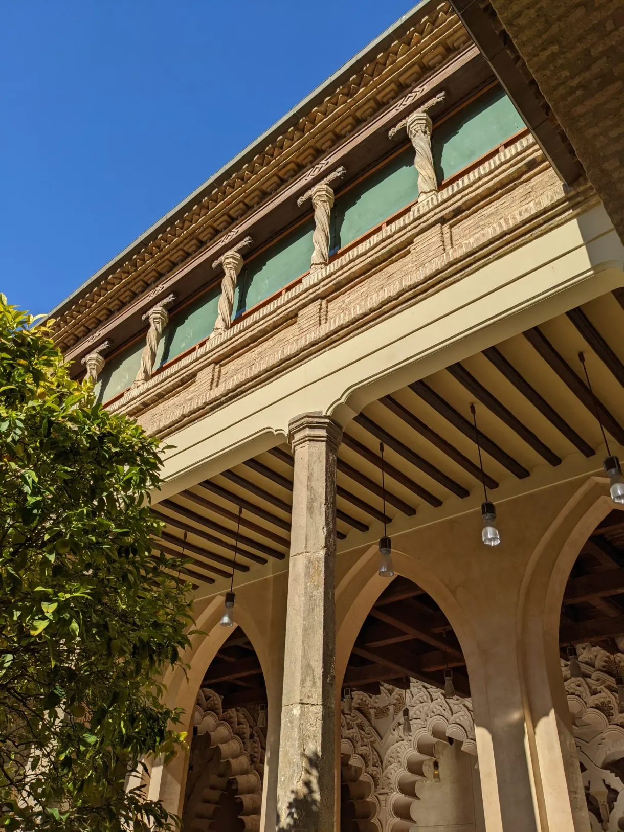 Galerie de bois sculpté surplombant les arcades du patio