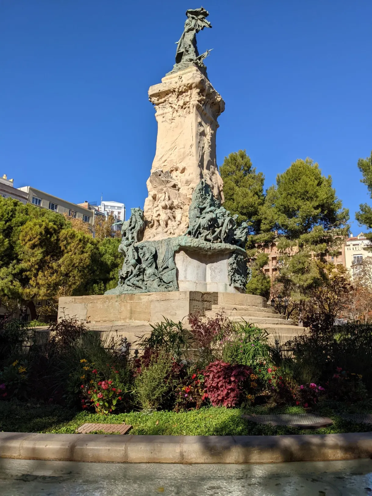 Monument sculpté au milieu d'un jardin fleuri