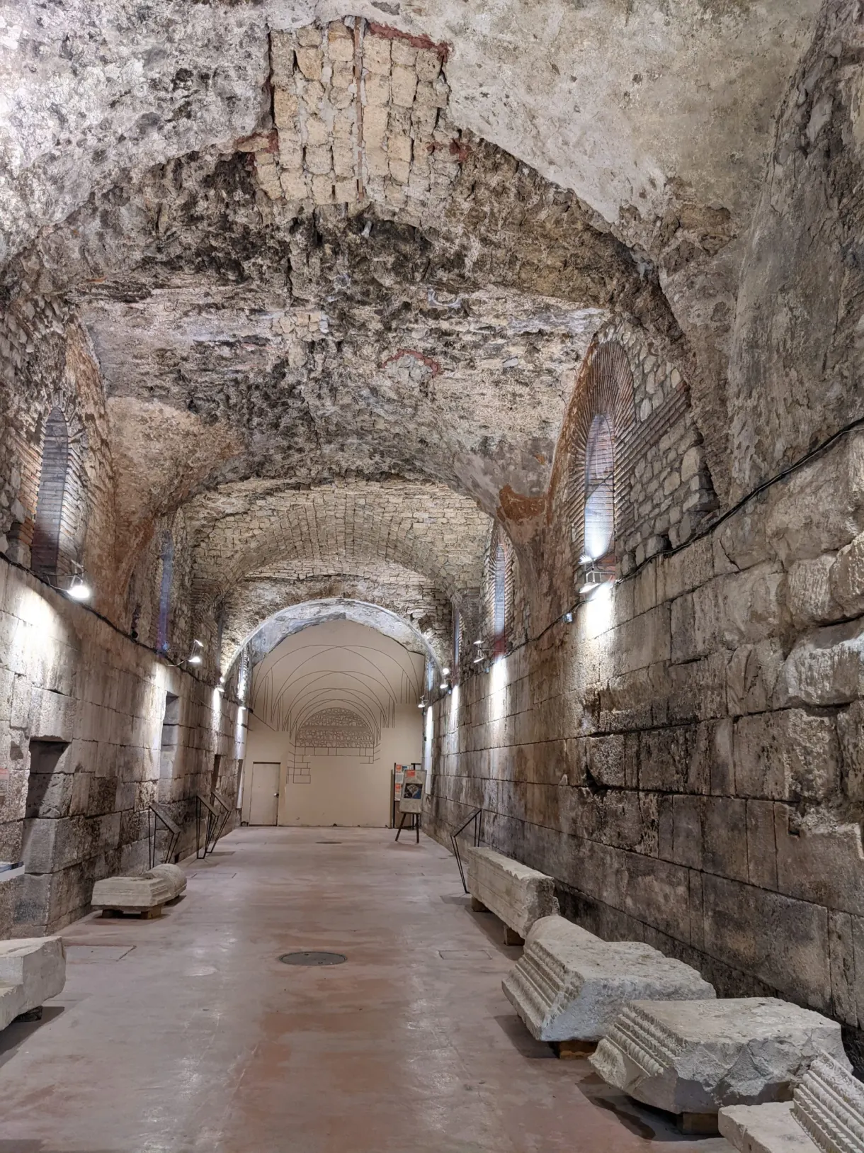 Vaste salle souterraine voûtée aux murs de pierre nue
