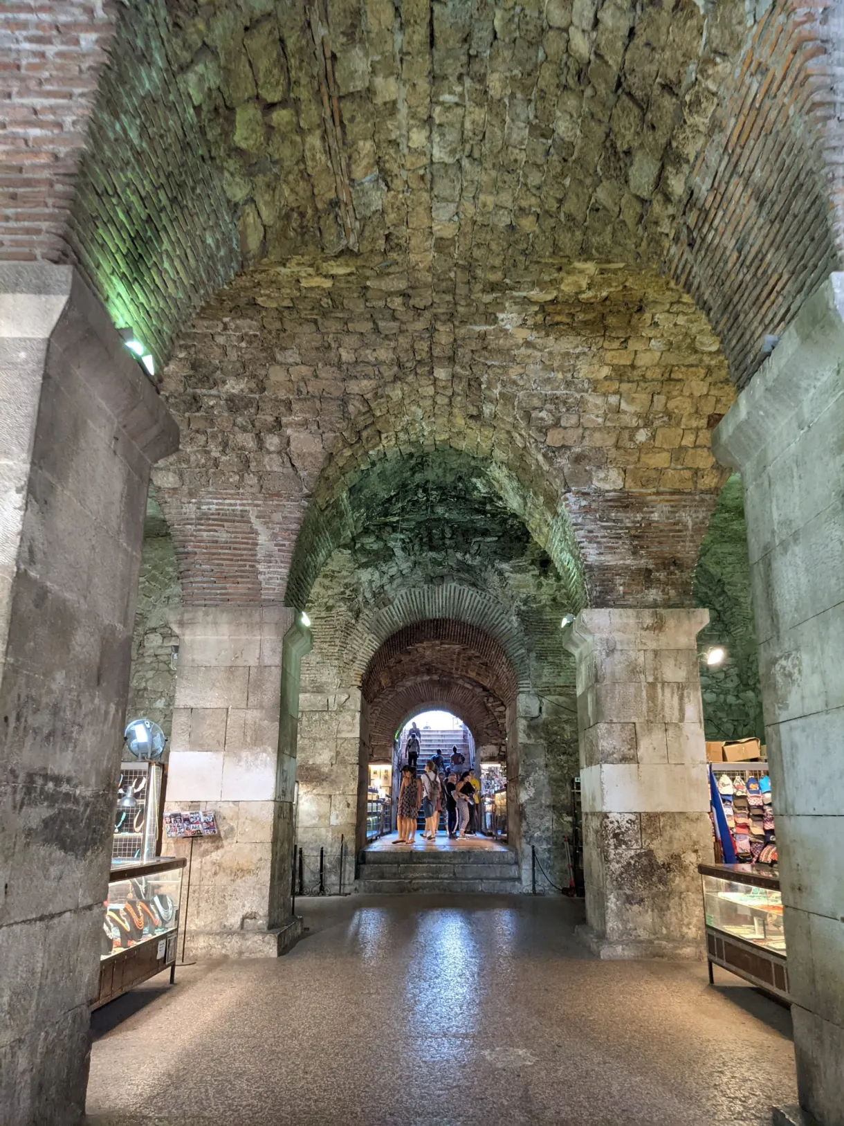 Caves voûtées éclairées avec boutiques et arche au fond