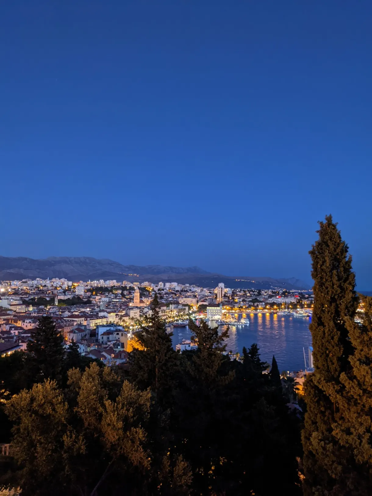 Ville illuminée et golfe à la tombée de la nuit
