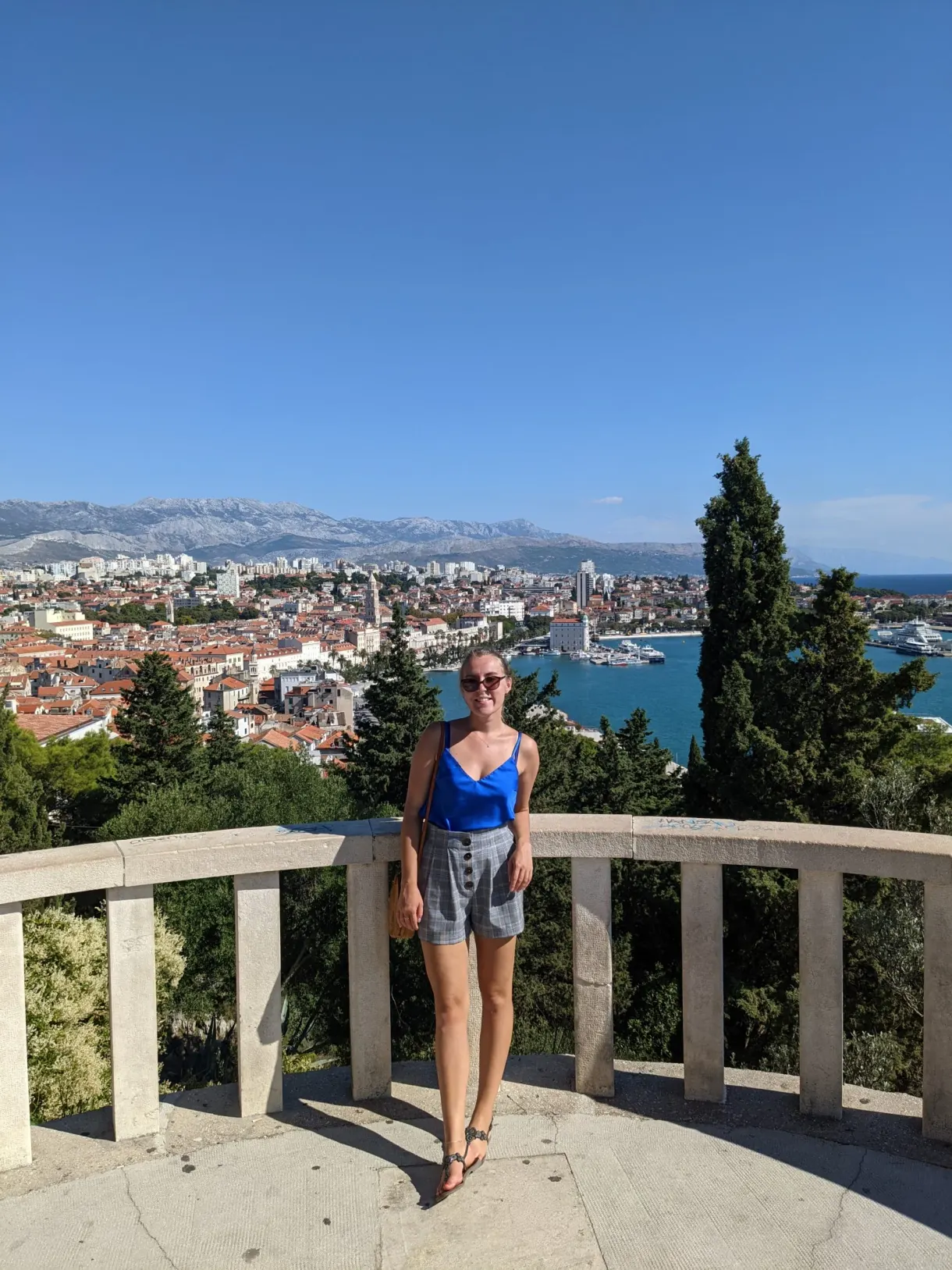 Femme accoudée à une balustrade panoramique au-dessus des toits