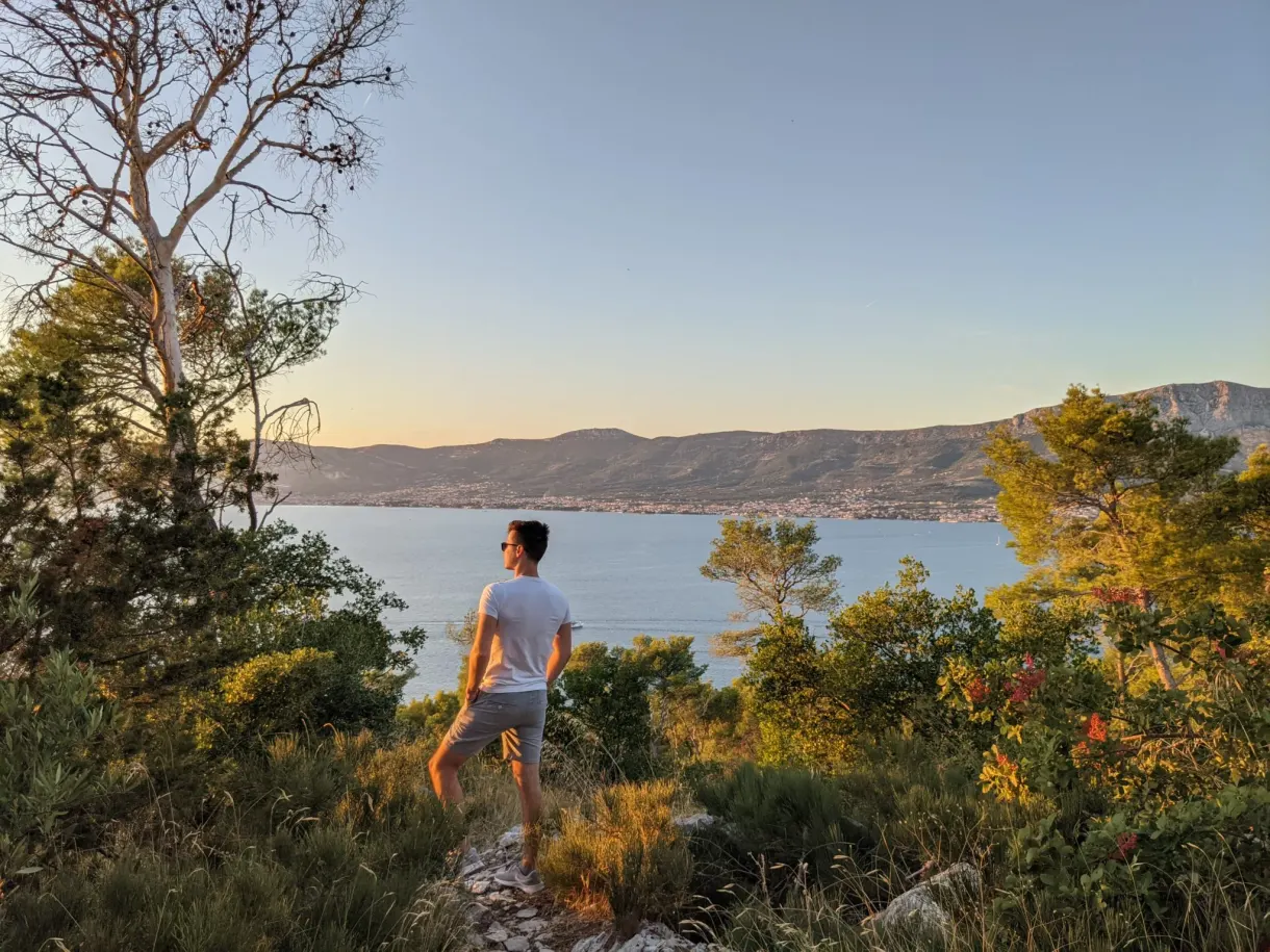 Homme debout sur un promontoire dans la lumière dorée
