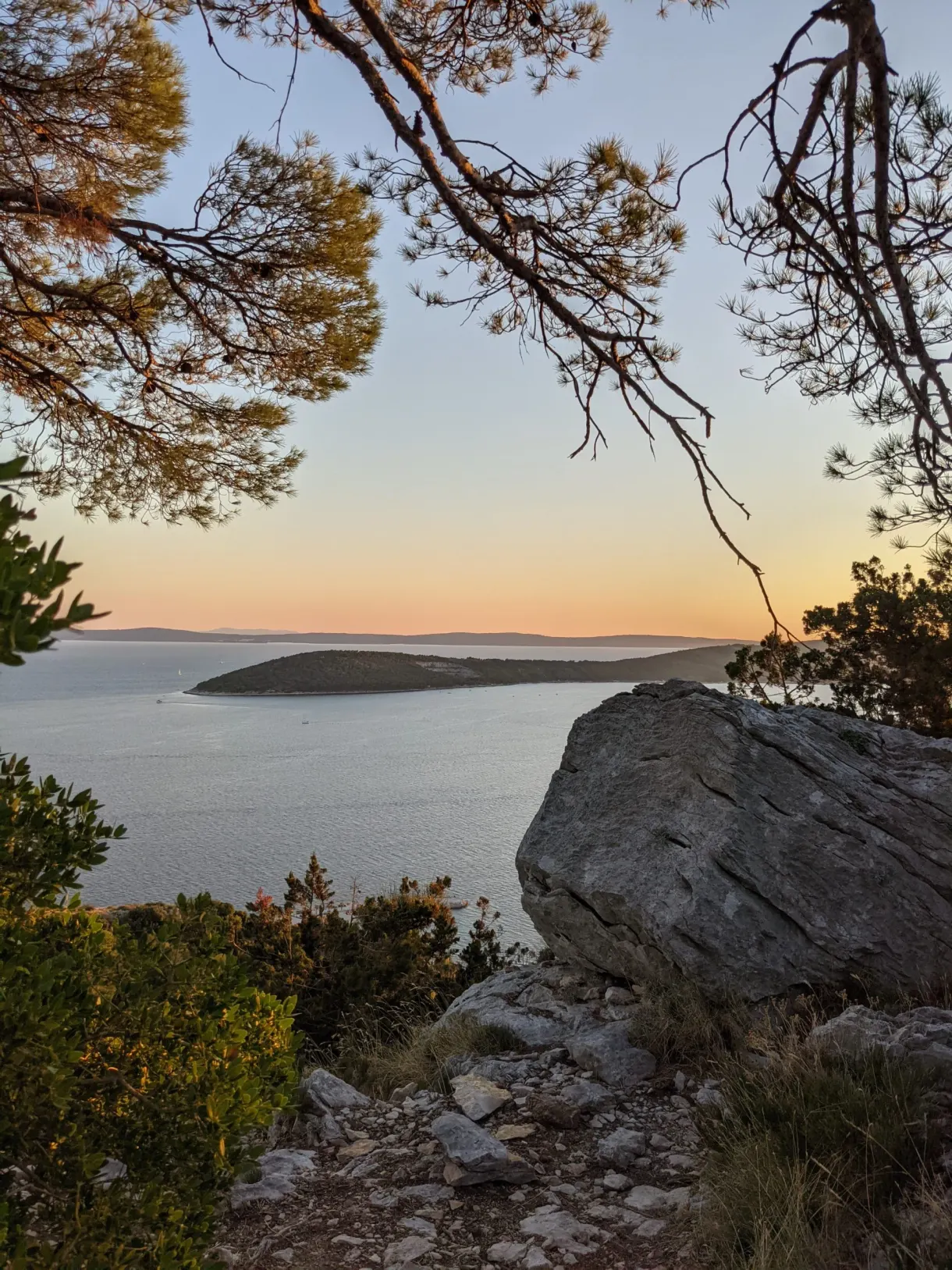 Gros rocher sur la crête, îles à l'horizon au couchant
