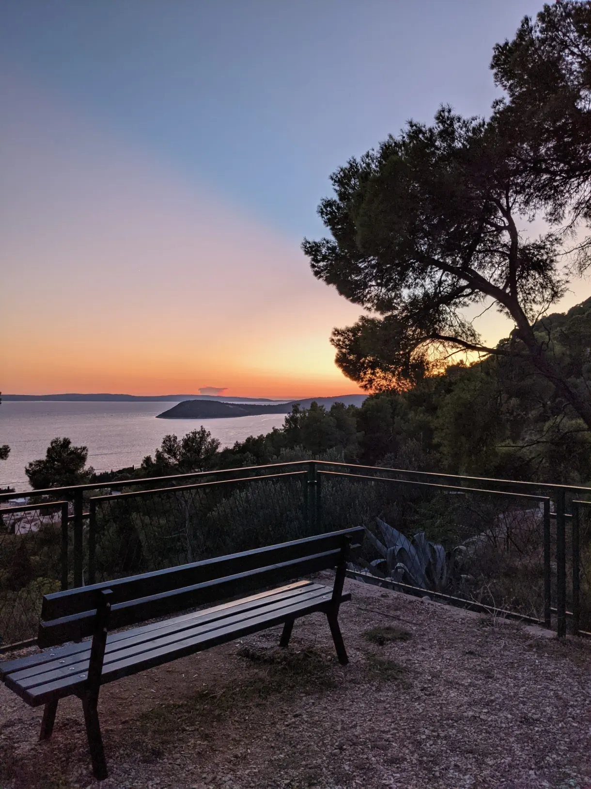 Banc de bois face à la mer au soleil couchant