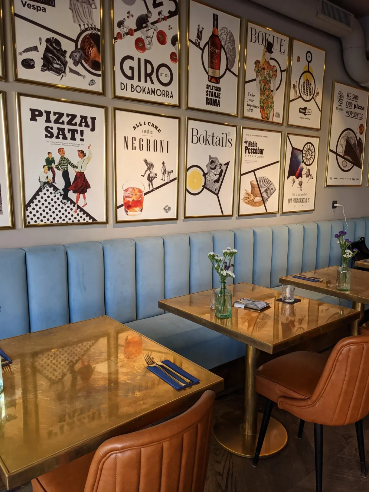 Banquette bleue et affiches colorées dans une pizzeria