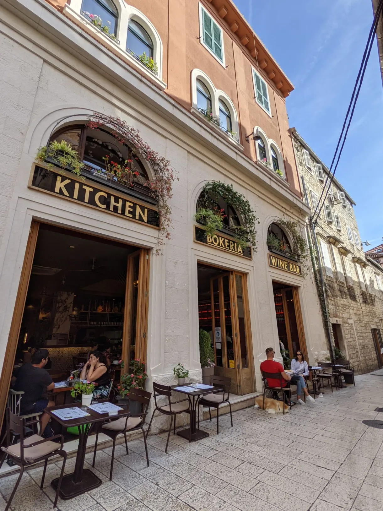 Terrasse d'un restaurant sous une façade à arcades