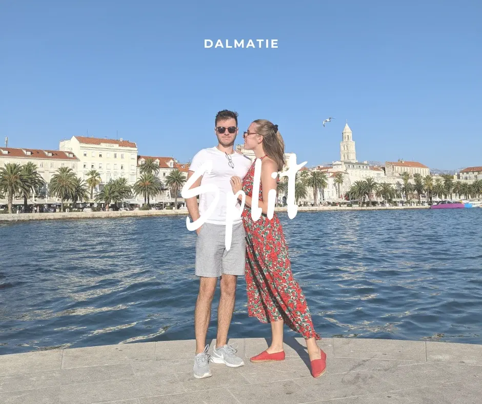Couple posant au bord de l'eau devant la vieille ville