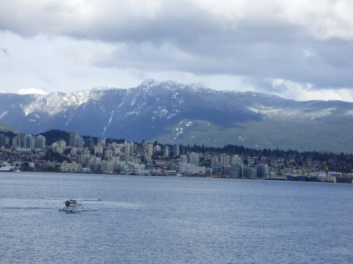 Hydravion glissant devant les montagnes enneigées de la rive nord