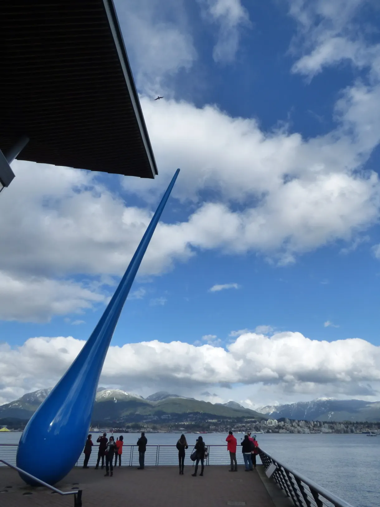 Sculpture en forme de goutte bleue géante et badauds