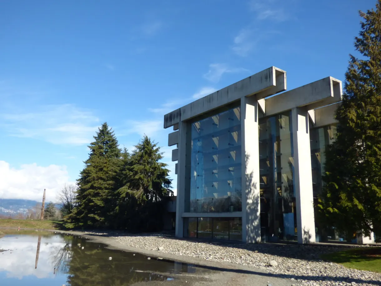 Bâtiment de béton et de verre reflété dans un bassin