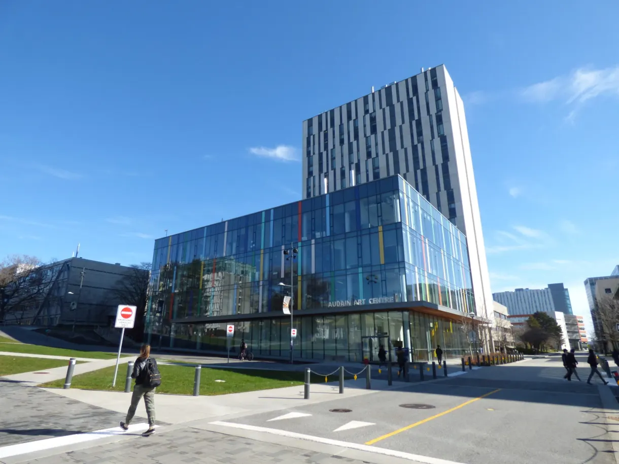 Bâtiment de verre du campus et passant sur le trottoir