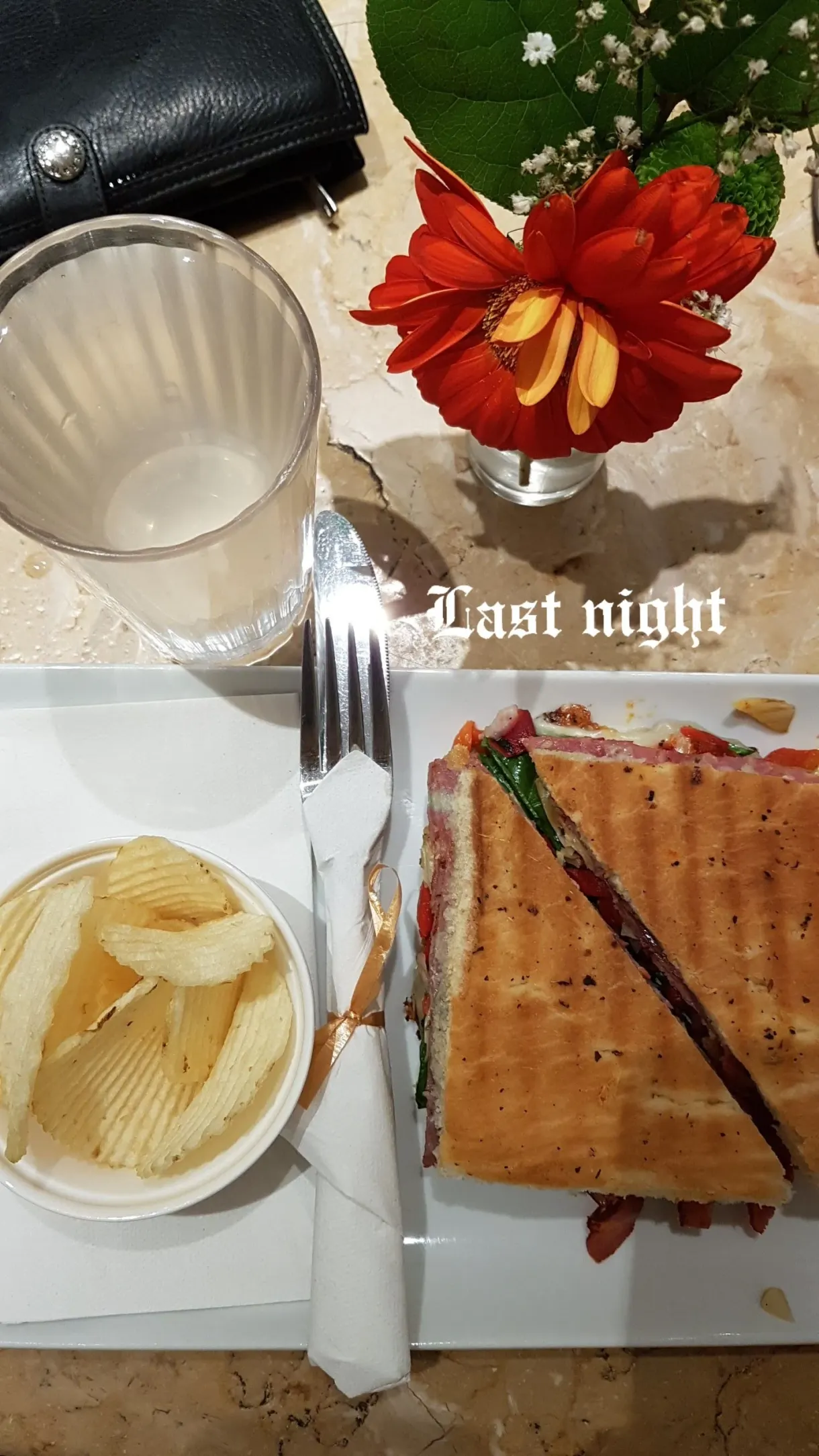 Sandwich grillé, chips et fleur rouge sur la table
