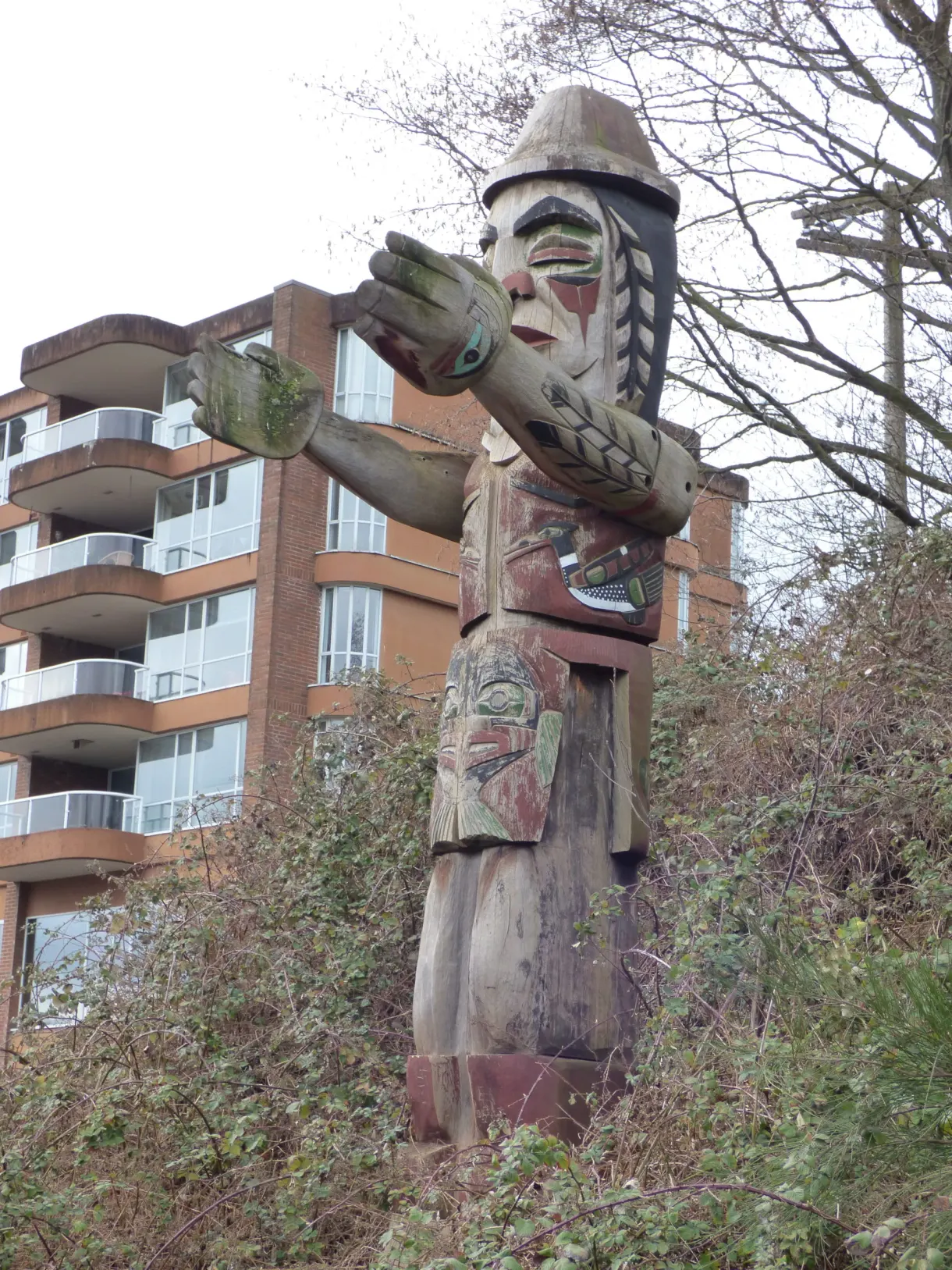 Totem sculpté dressé devant un immeuble résidentiel