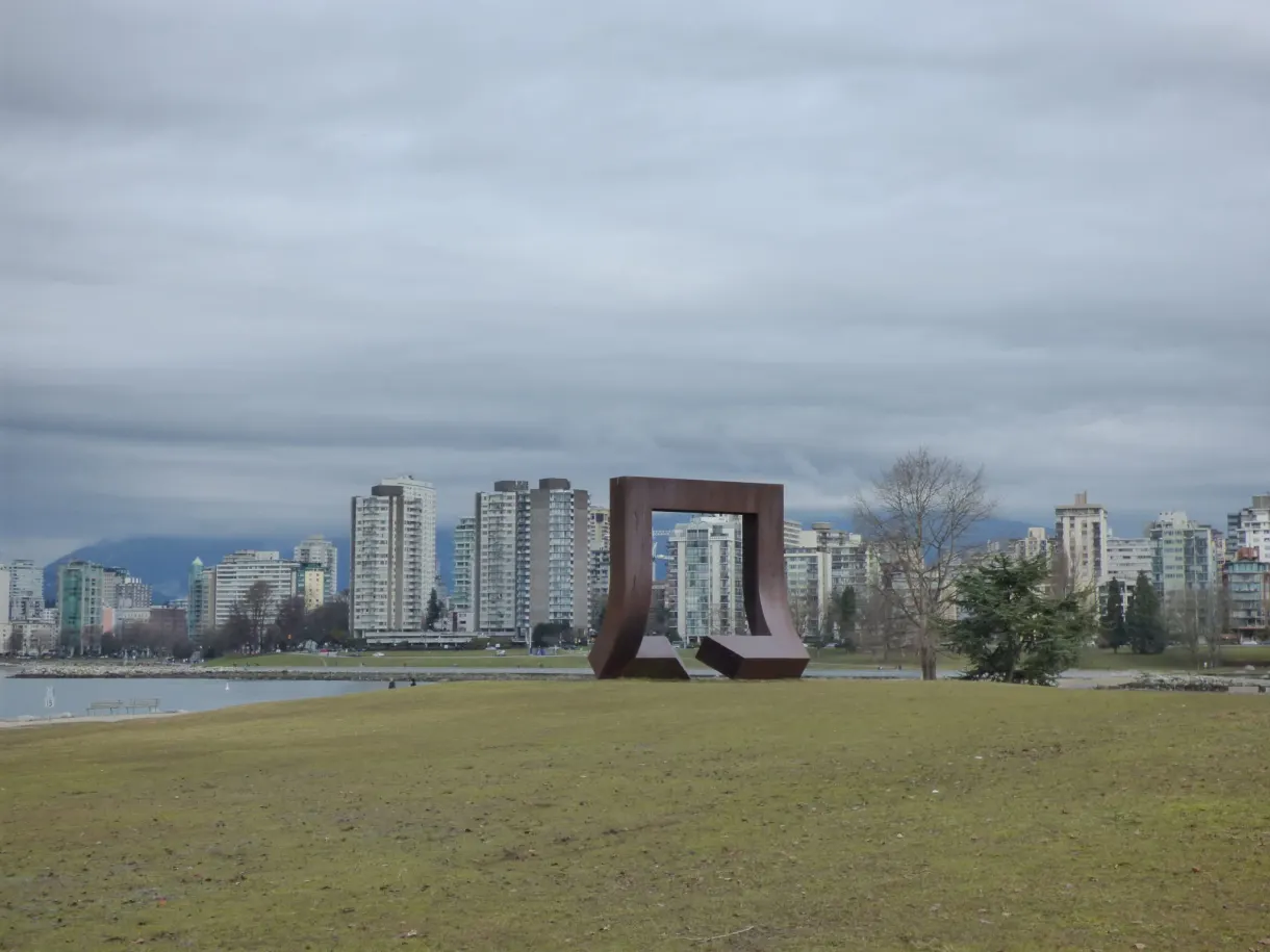Sculpture d'acier sur la pelouse face aux tours