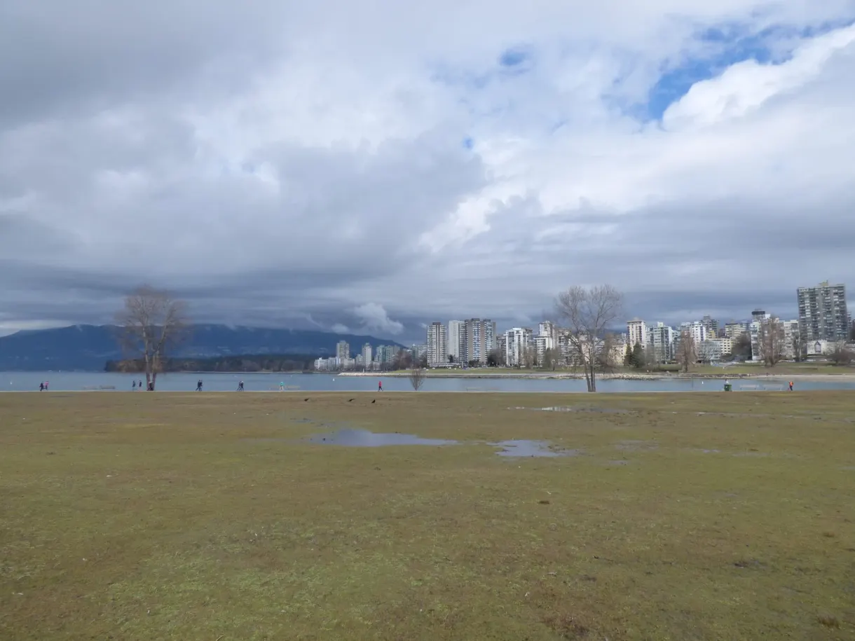 Vaste pelouse détrempée ouvrant sur la ville au loin