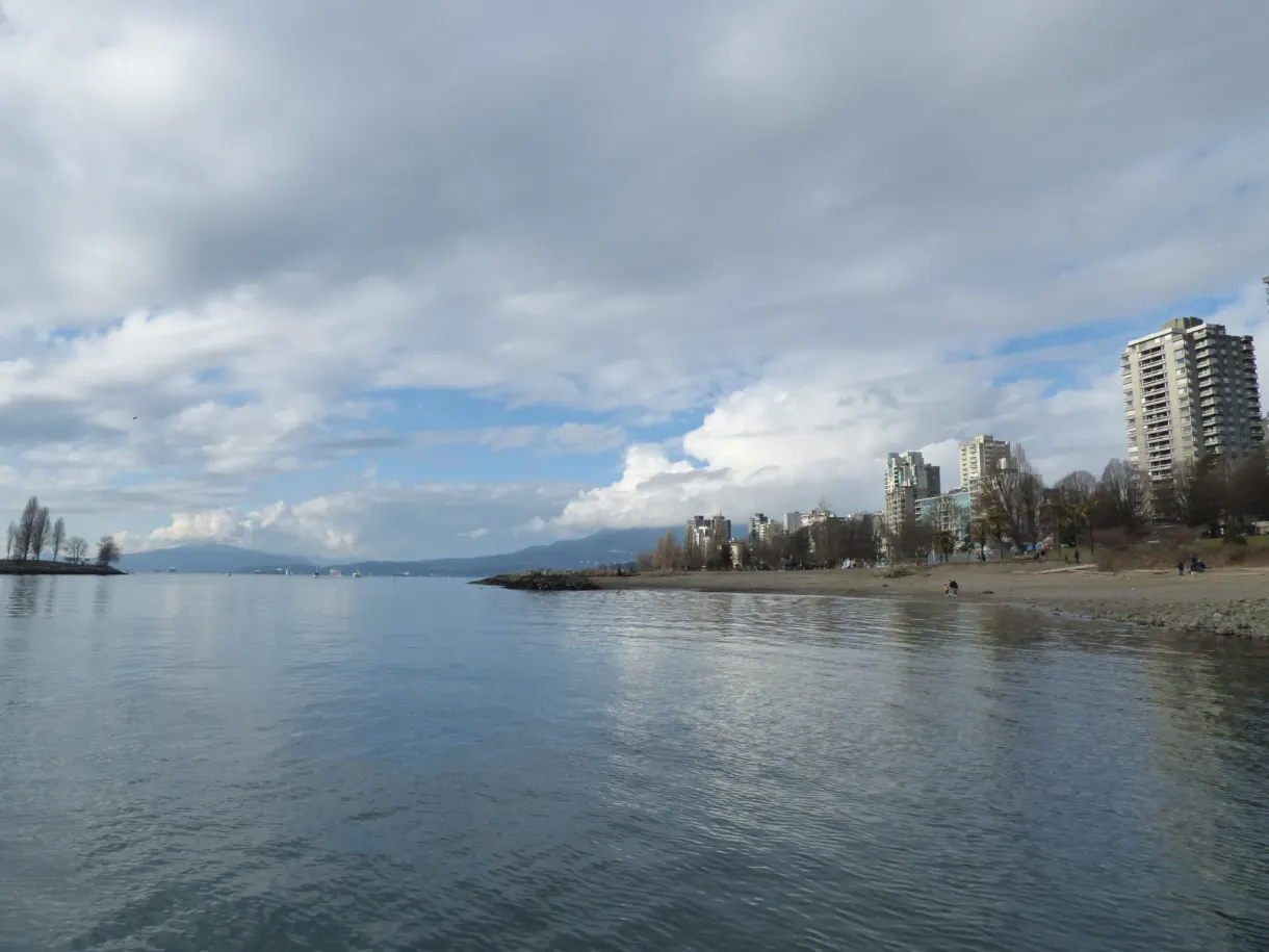 Plage de galets ouvrant sur les immeubles de la baie