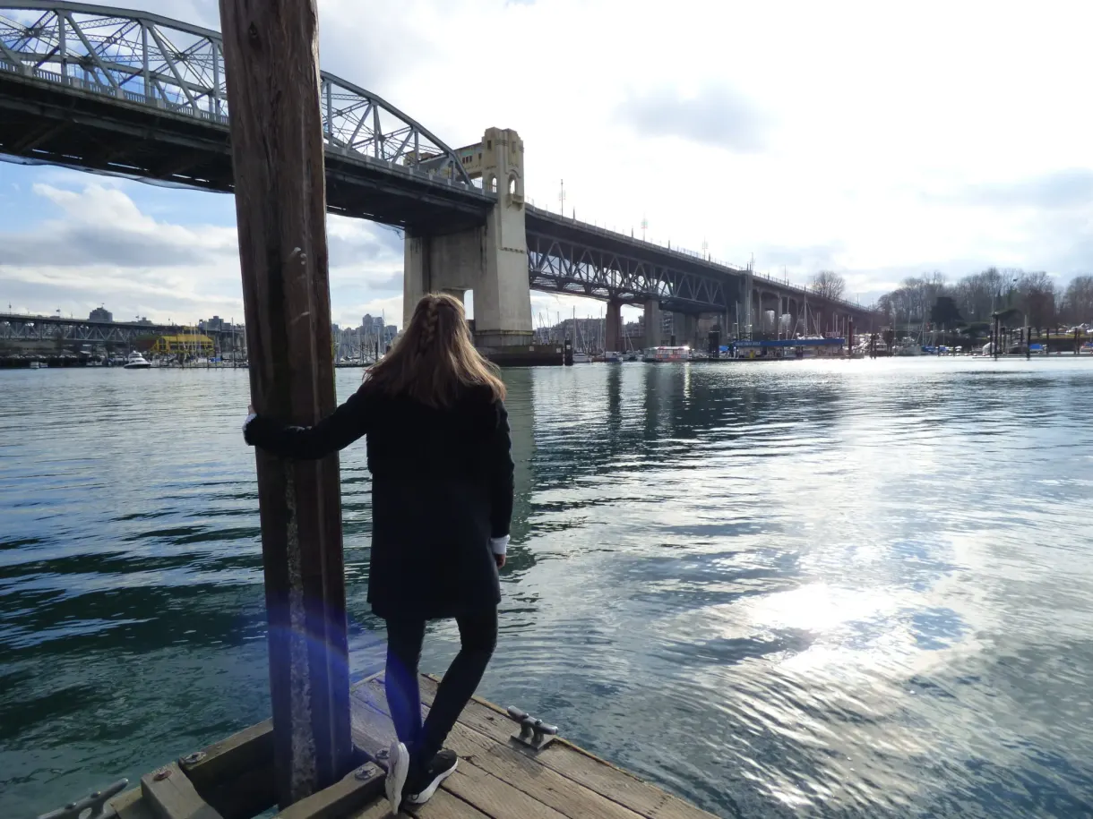 Femme appuyée à un pilier de ponton sous le pont