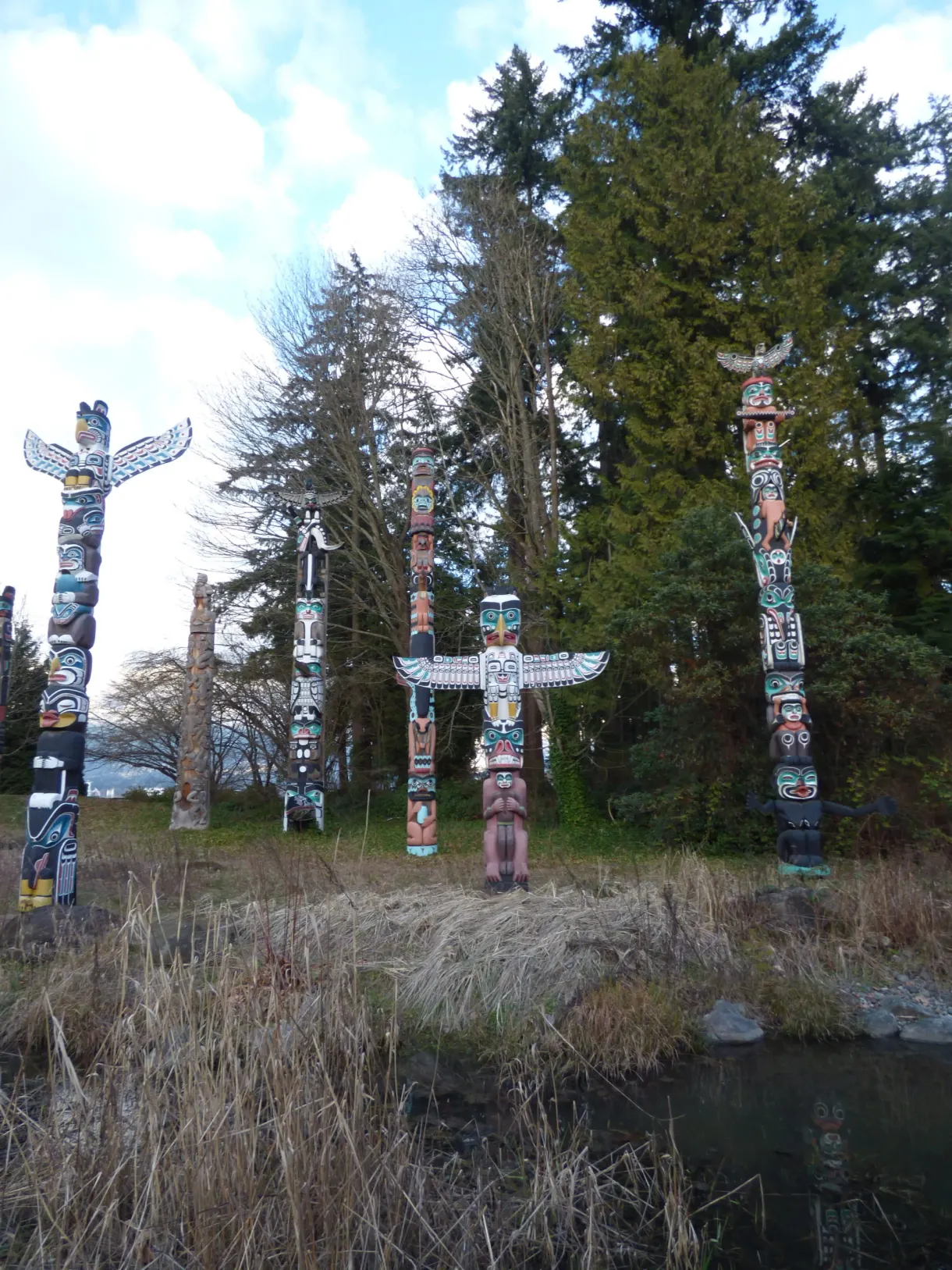 Totems dressés dans une clairière de conifères