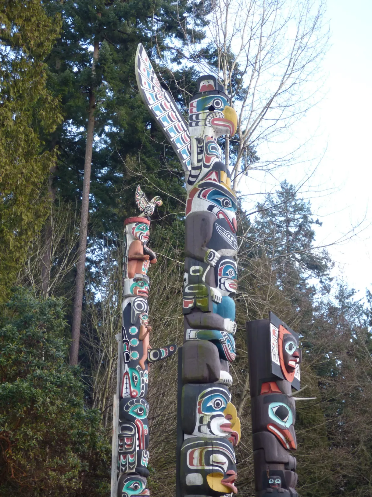 Totems en contre-plongée, aigle sculpté au sommet