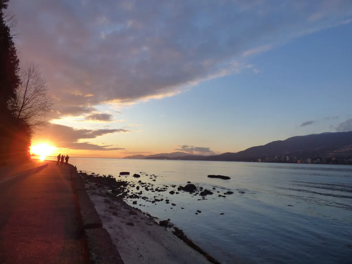Promeneurs en silhouette devant le soleil rasant