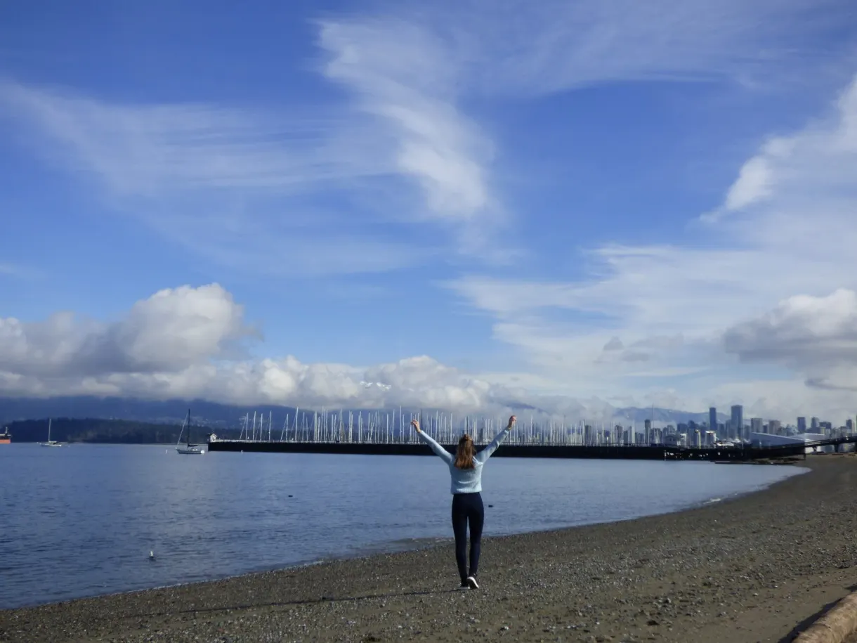 Bras levés sur la plage sous un ciel de cirrus