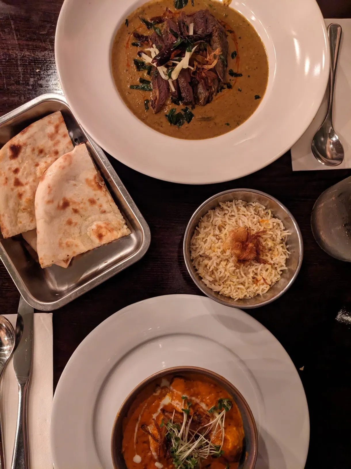 Currys, naan et riz posés sur une table sombre