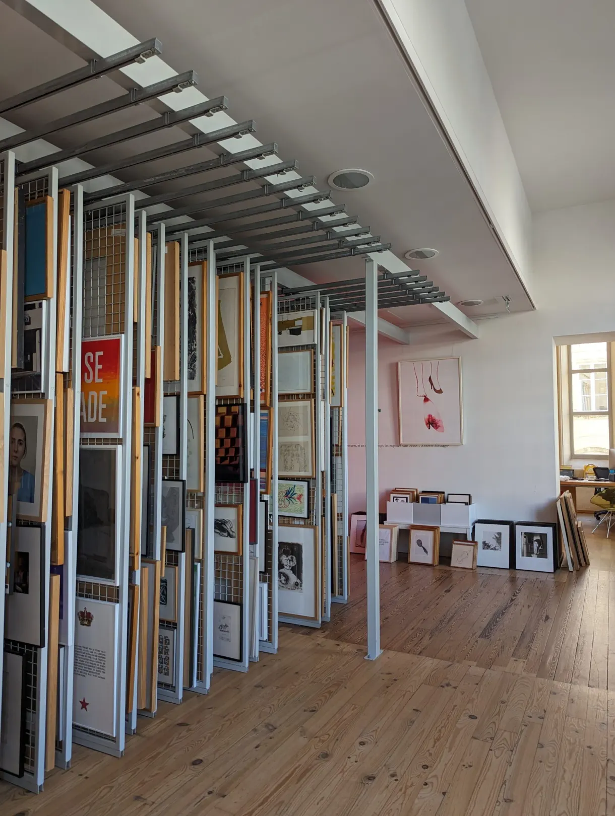 Cimaises mobiles chargées d'affiches dans une galerie au parquet clair