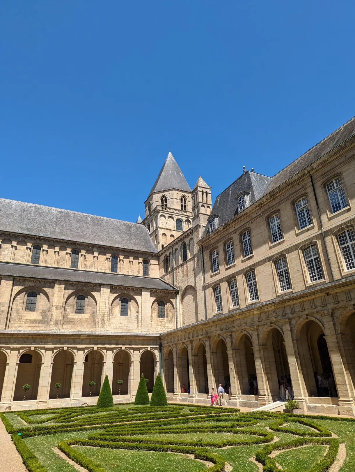 Cloître à arcades entourant un jardin de buis taillé
