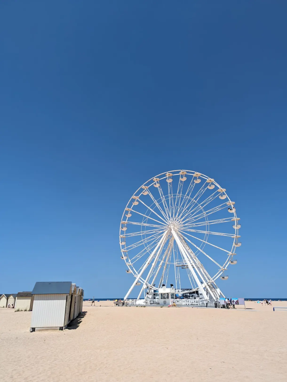 Grande roue blanche dressée sur la plage de sable