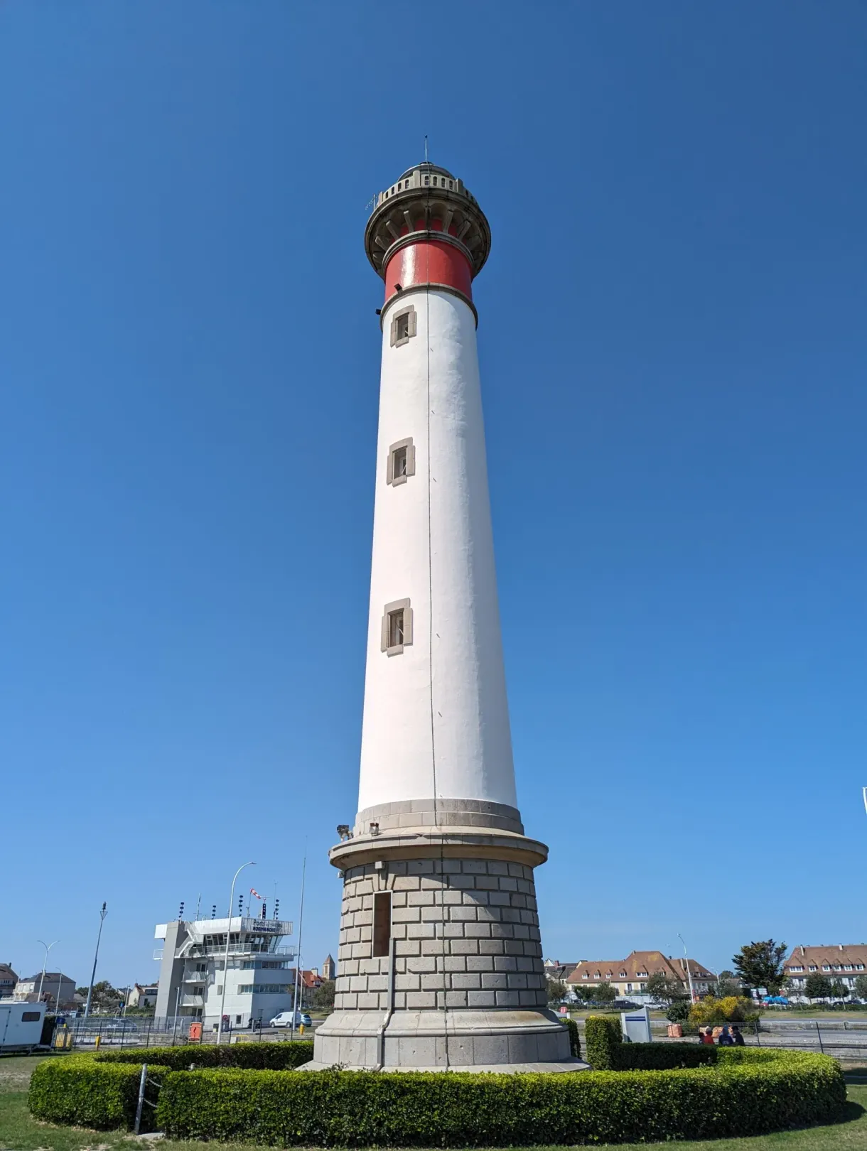 Phare blanc à couronne rouge dominant le port de Ouistreham