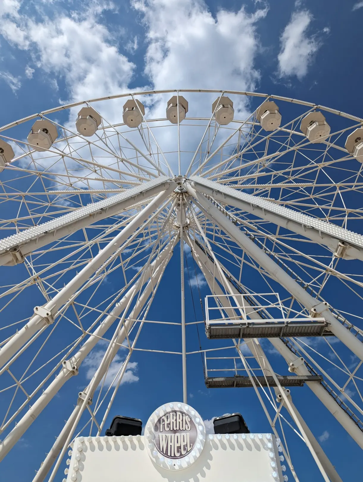 Contre-plongée sur les nacelles et les rayons de la grande roue