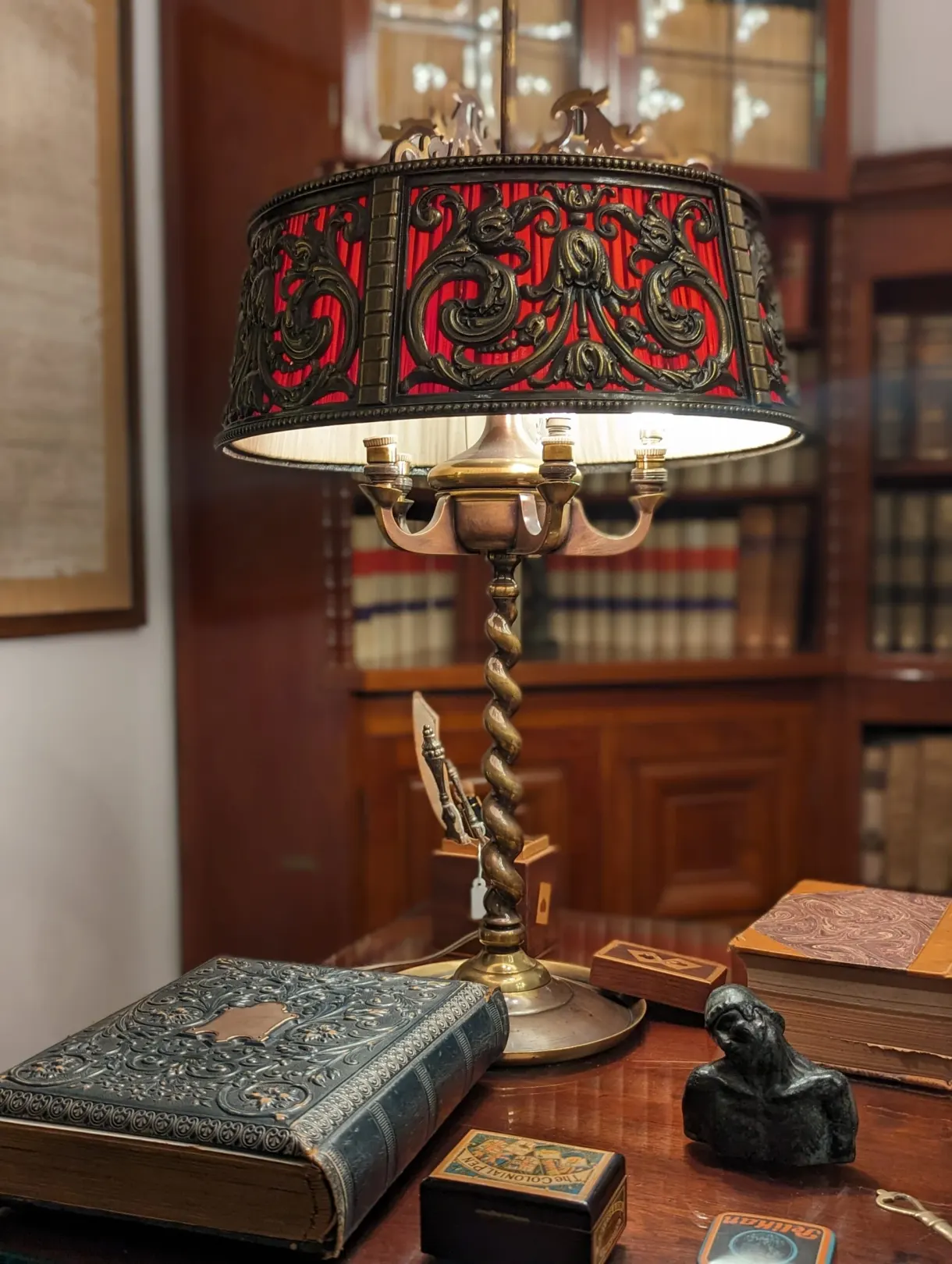 Lampe art nouveau à abat-jour rouge sur un bureau de bibliothèque