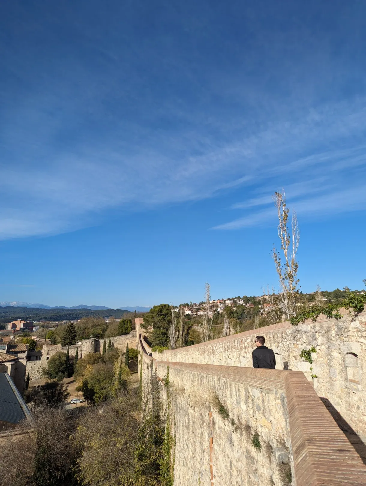 Promeneur sur le chemin de ronde des murailles, ciel dégagé