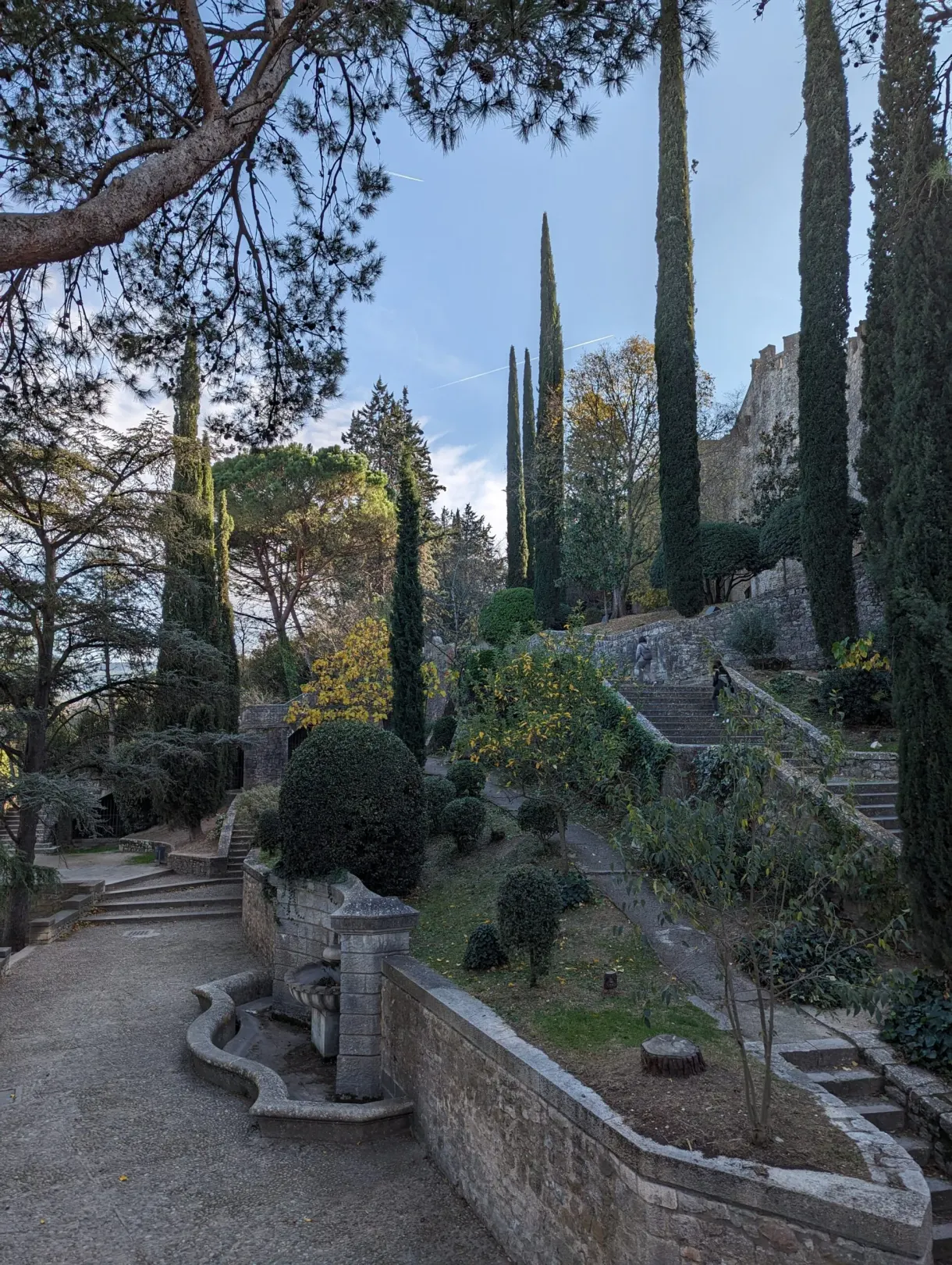 Jardins en terrasses plantés de cyprès au pied des remparts