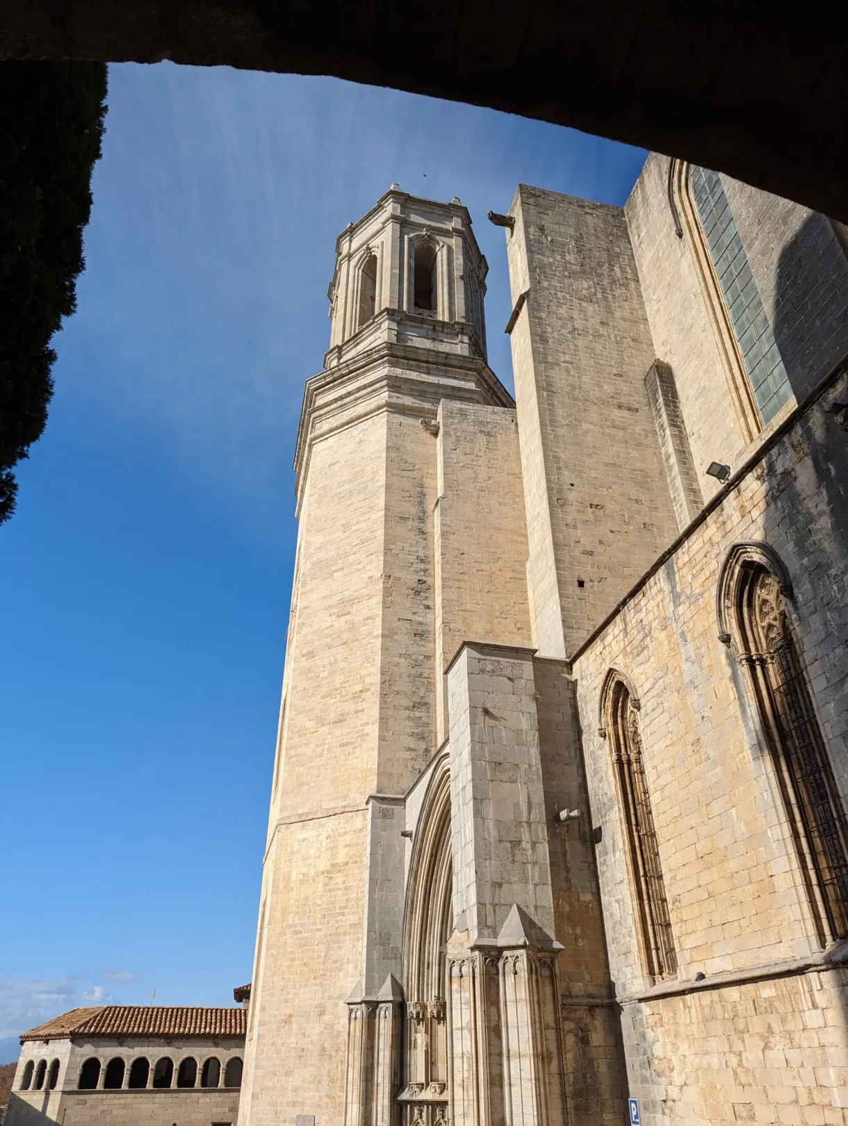 Clocher carré de la cathédrale cadré sous une arche de pierre