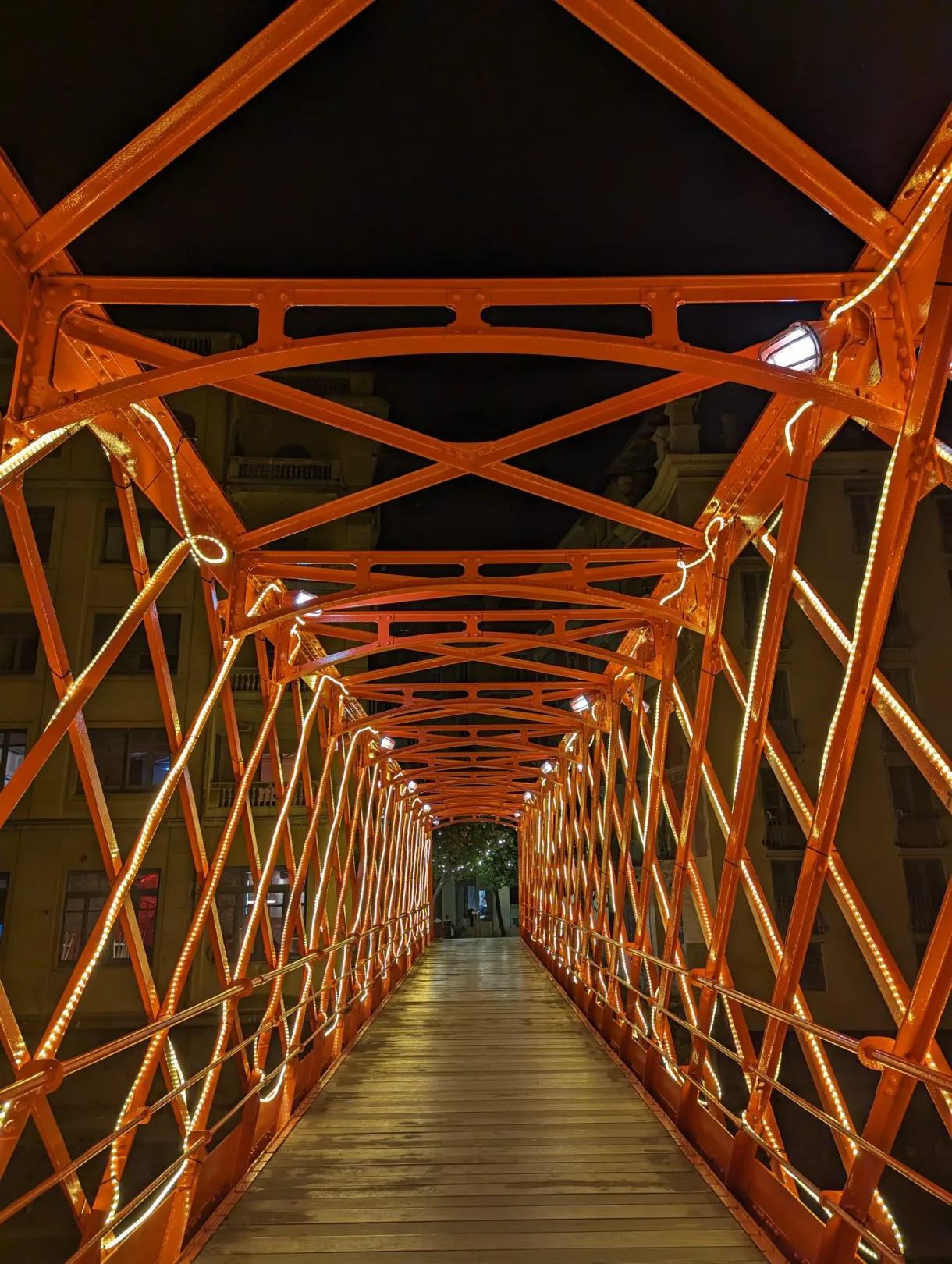 Passerelle métallique orange illuminée de l'intérieur à la nuit tombée
