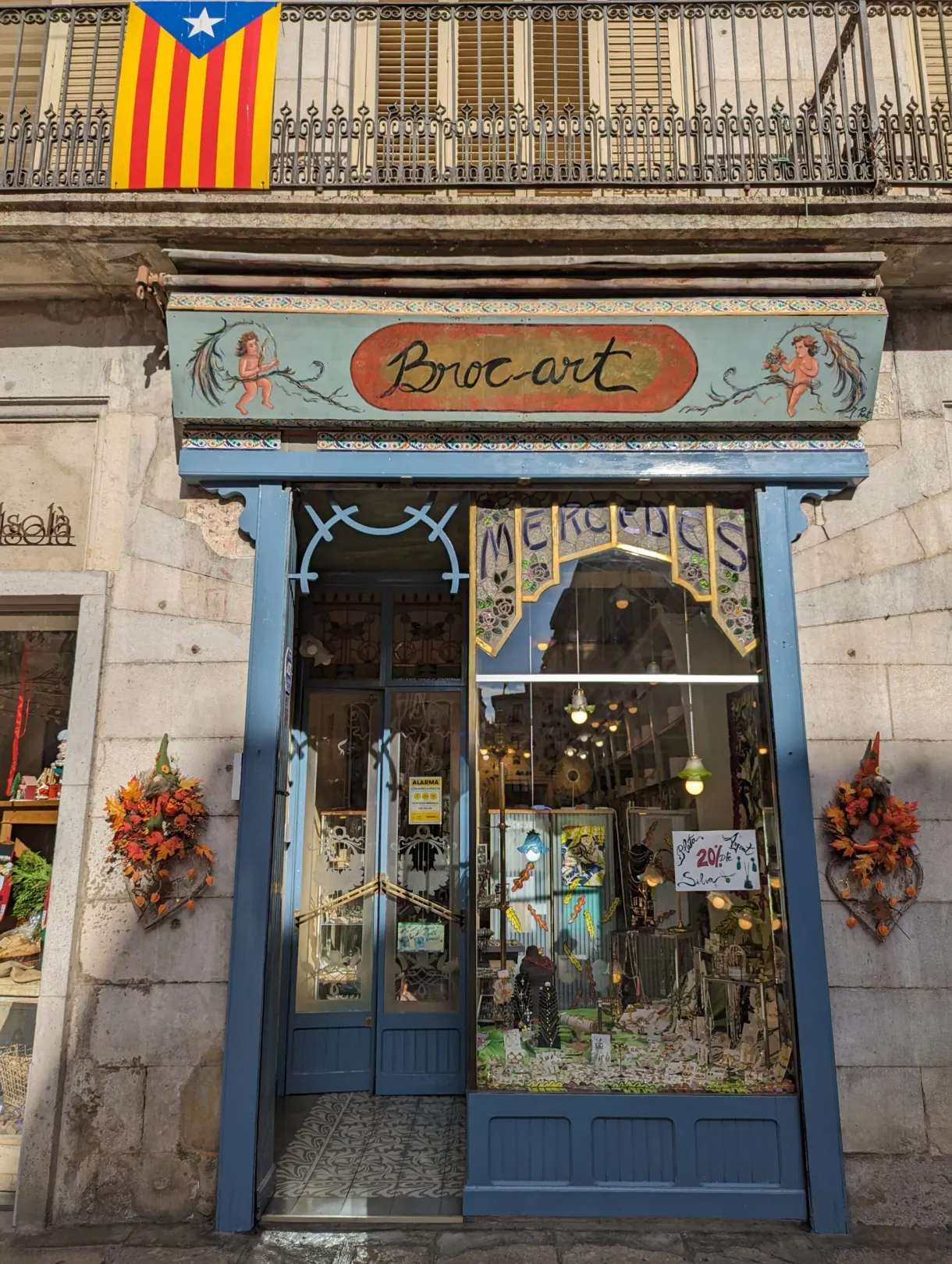 Devanture bleue d'une boutique de brocante sous un drapeau catalan