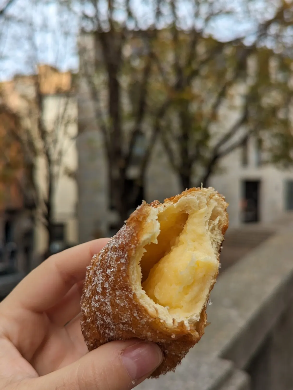 Beignet fourré à la crème tenu à la main dans la rue