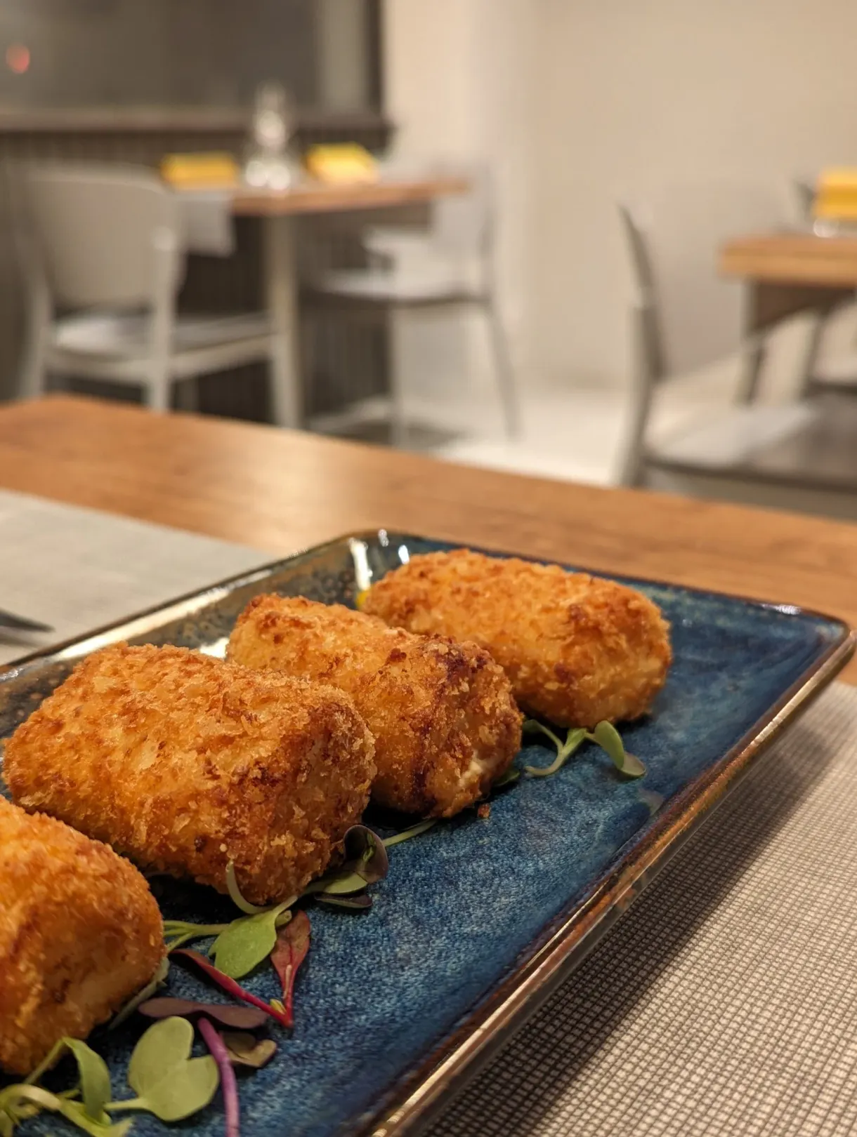 Croquettes dorées alignées sur une assiette bleue