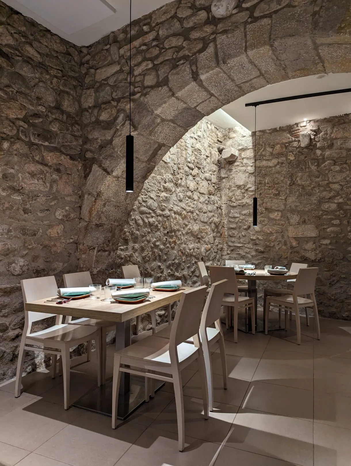 Salle de restaurant dressée sous une voûte de pierre ancienne