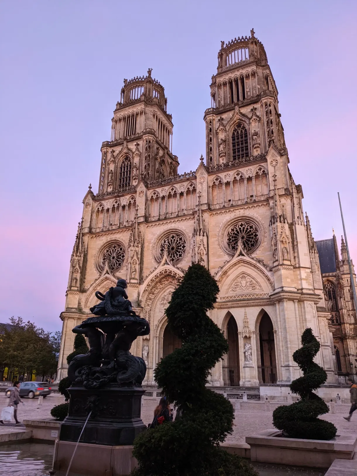 Ciel rose derrière les tours et les ifs taillés