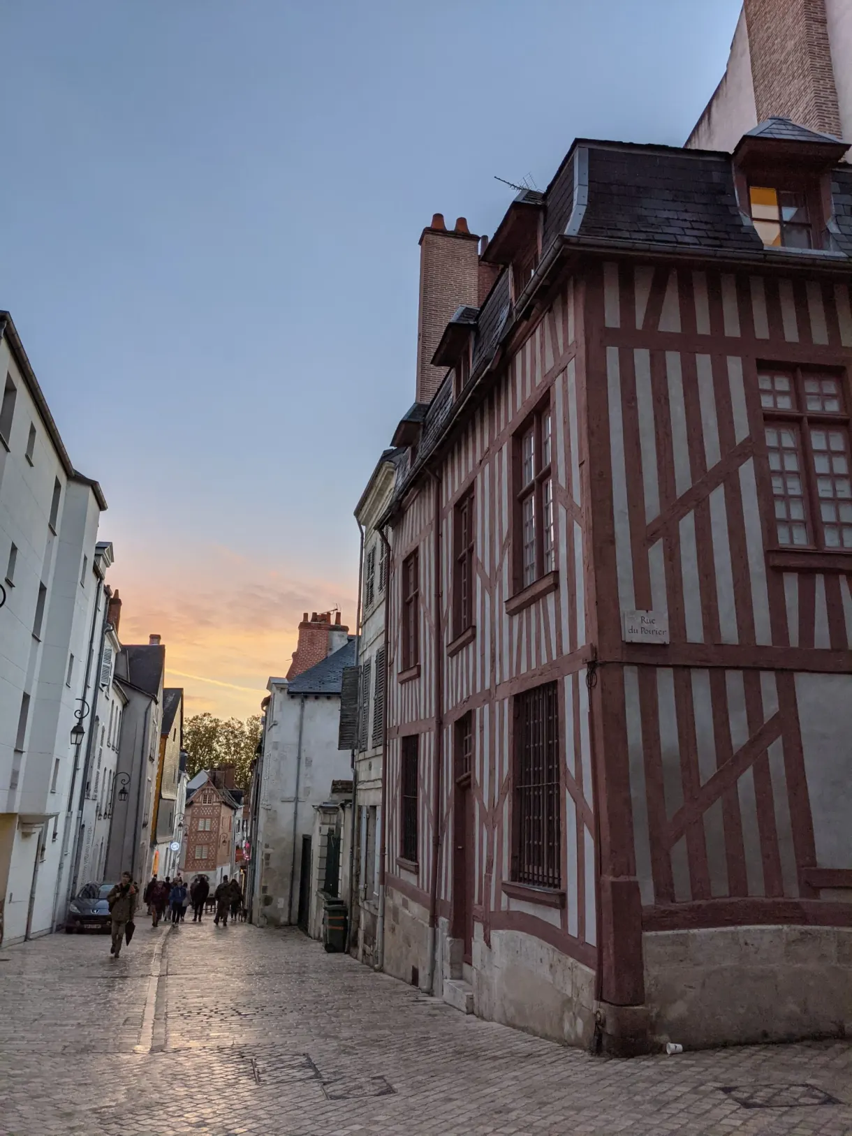 Maison à colombages rouges à l'angle d'une rue au crépuscule