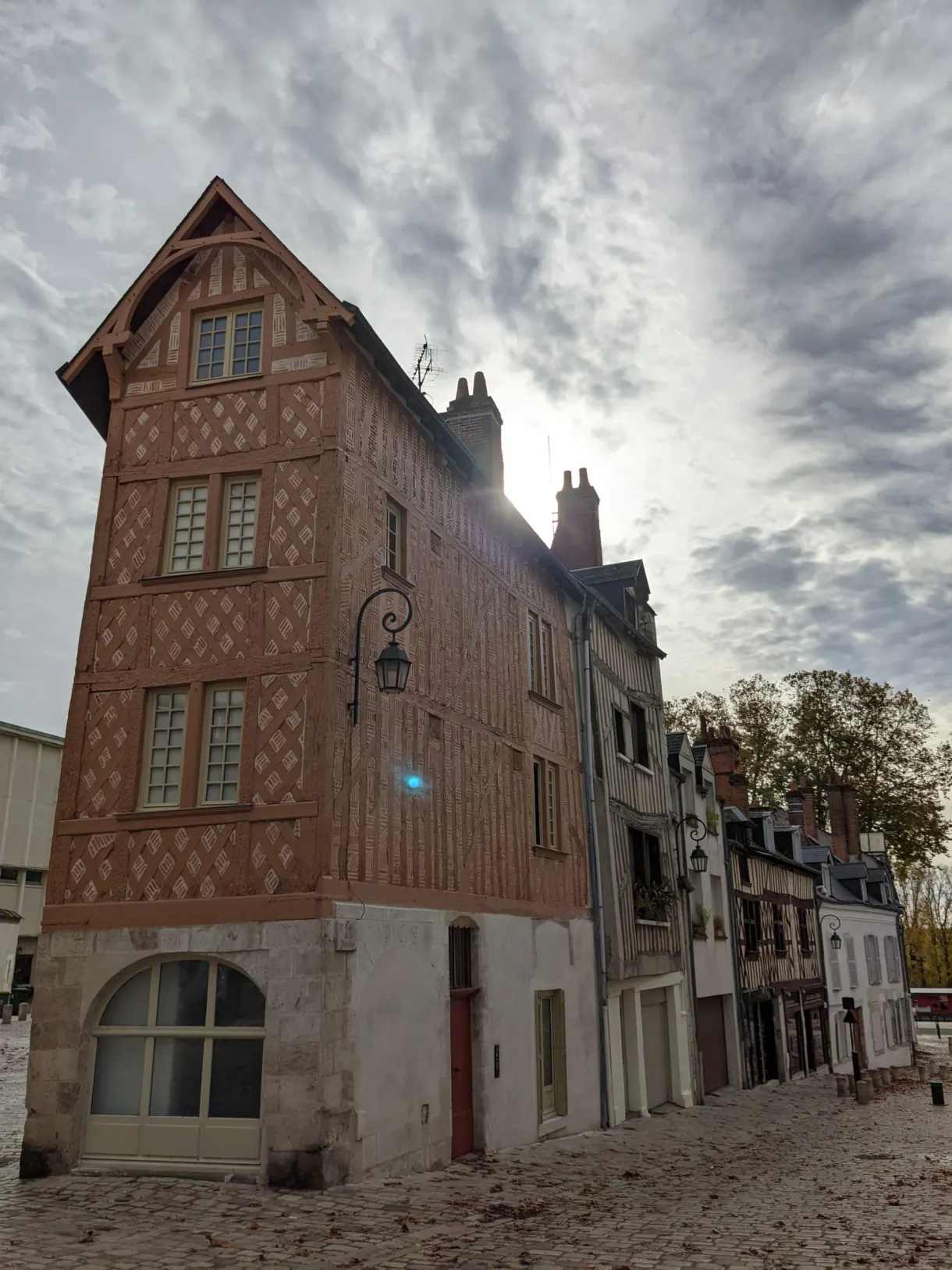 Haute maison à pans de bois isolée en bord de place