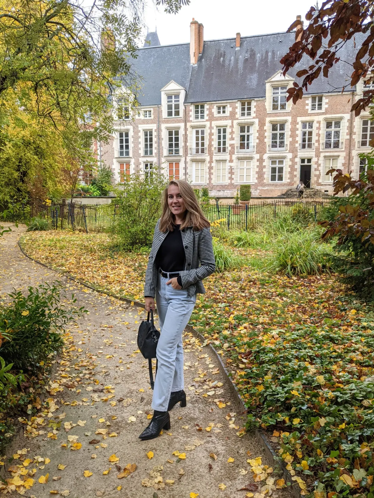 Allée couverte de feuilles devant un hôtel particulier