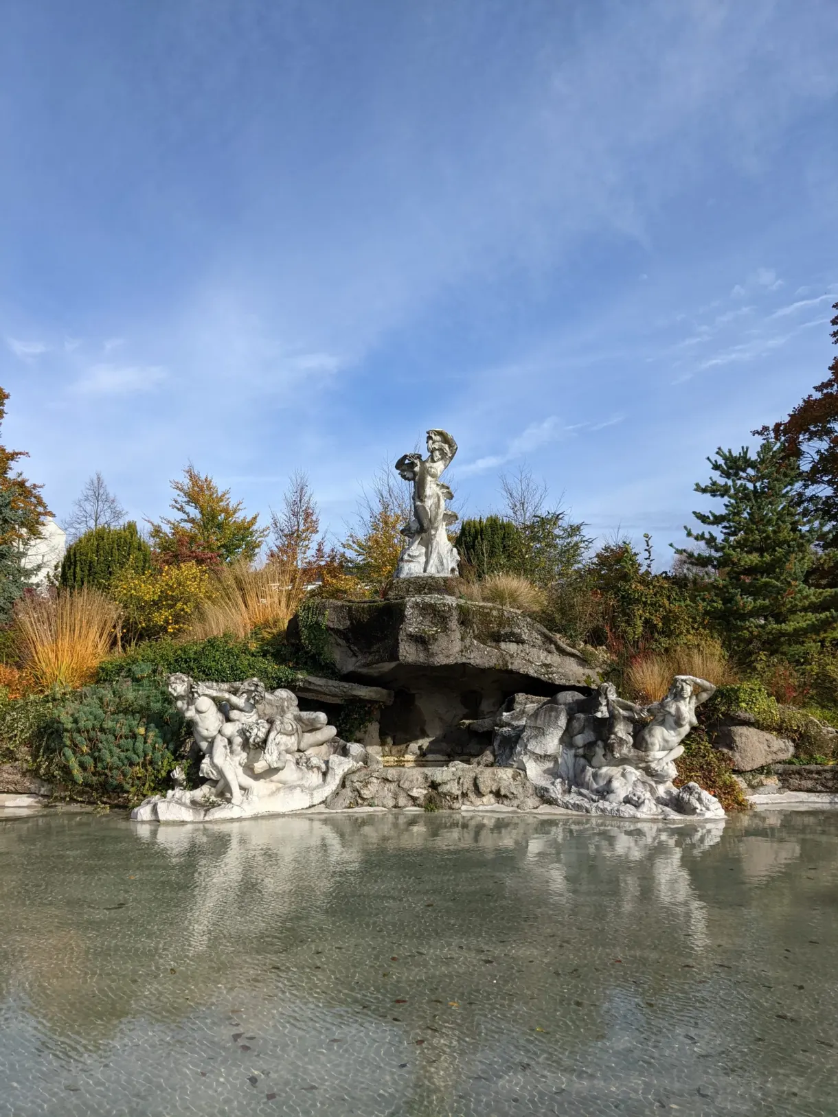 Rocaille et statue au-dessus d'un bassin du parc