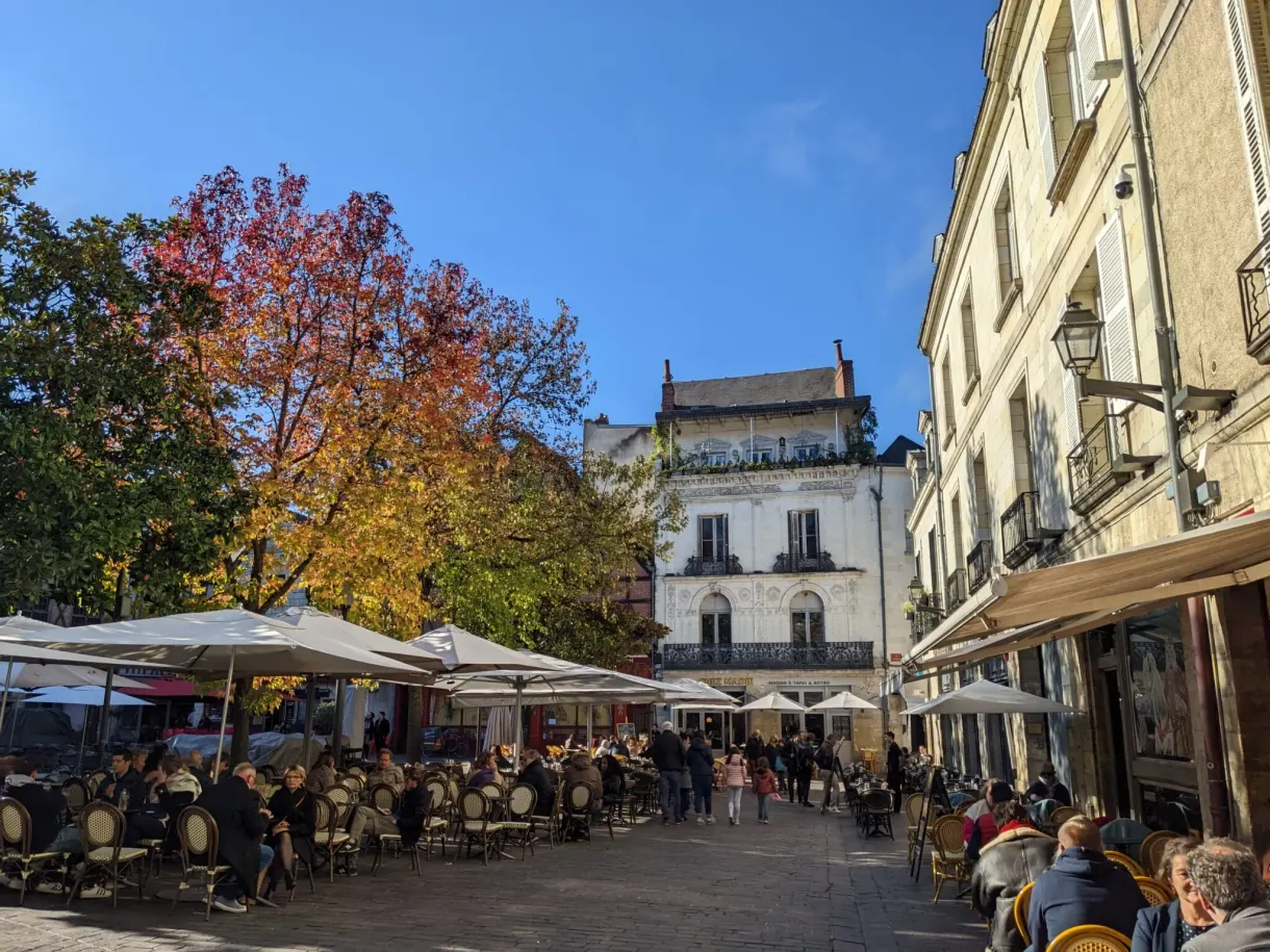 Terrasses de café bondées sur une place du Vieux-Tours en automne