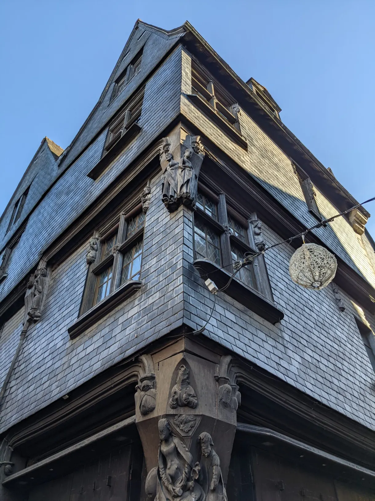 Encorbellement d'ardoise et consoles sculptées à l'angle d'une maison ancienne