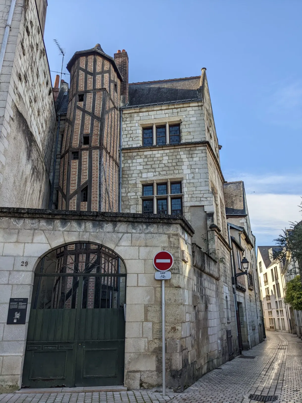 Ruelle en pente entre maison à colombages et mur de pierre